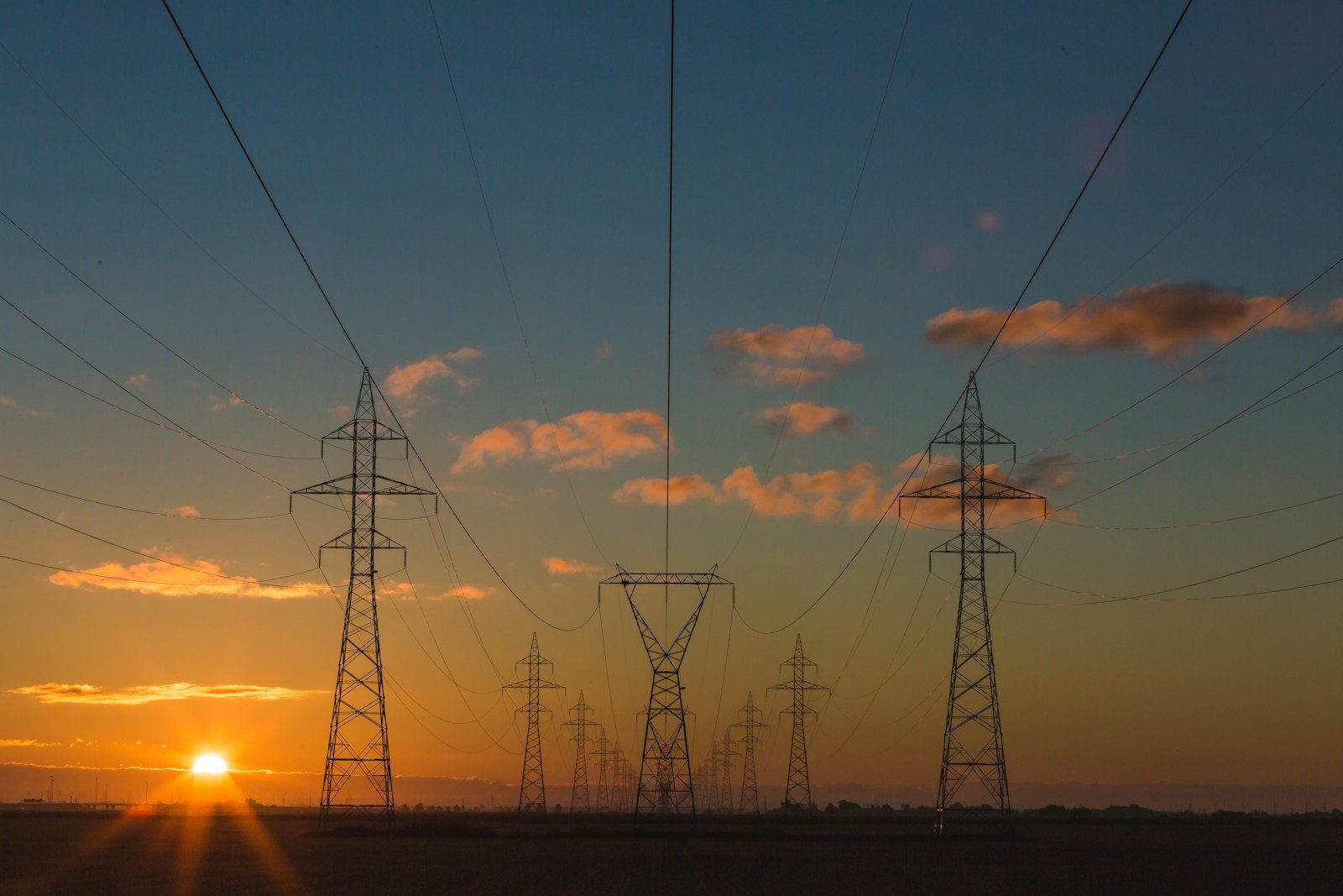 Transmission towers against a sunrise sky